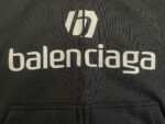 Felpa noir Balenciaga con logo stilizzato e branding audace, stile streetwear di lusso.