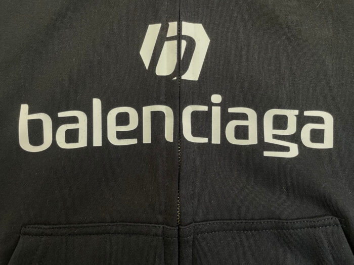 Felpa noir Balenciaga con logo stilizzato e branding audace, stile streetwear di lusso.