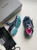 Sneakers Balenciaga di lusso con design moderno, colori vivaci e confezione elegante.