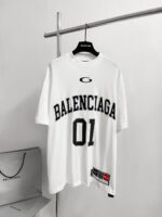 Maglietta oversize bianca Balenciaga con logo e dettaglio logo, stile sportivo e moda urbana.