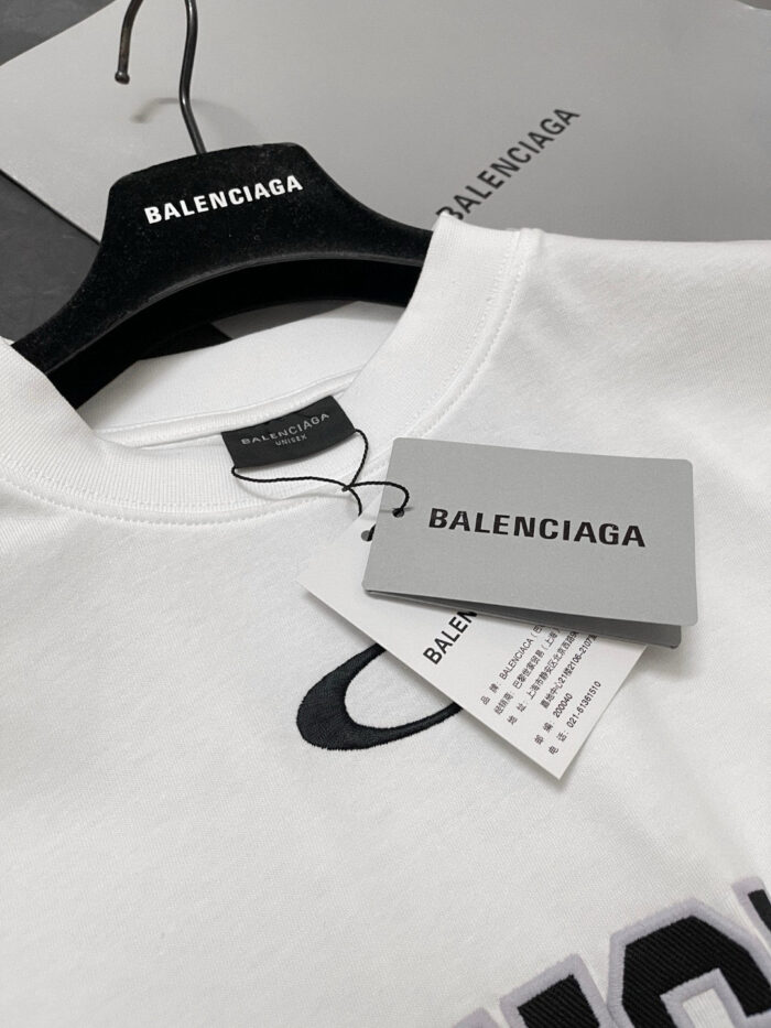 Maglietta bianca Balenciaga con logo nero, etichette eleganti e presentatione minimalista raffinata.