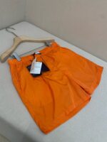 Pantaloncini da spiaggia arancioni leggeri, ideali per estate, sport e relax allaperto.