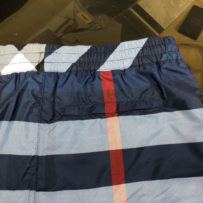 Costume da bagno a righe blu navy e rosso, estilo sportivo e multifunctionale estivo.
