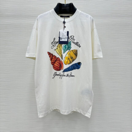 Maglietta estiva con conchiglie colorate e messaggio Greetings from the Sea per look casual e beach.