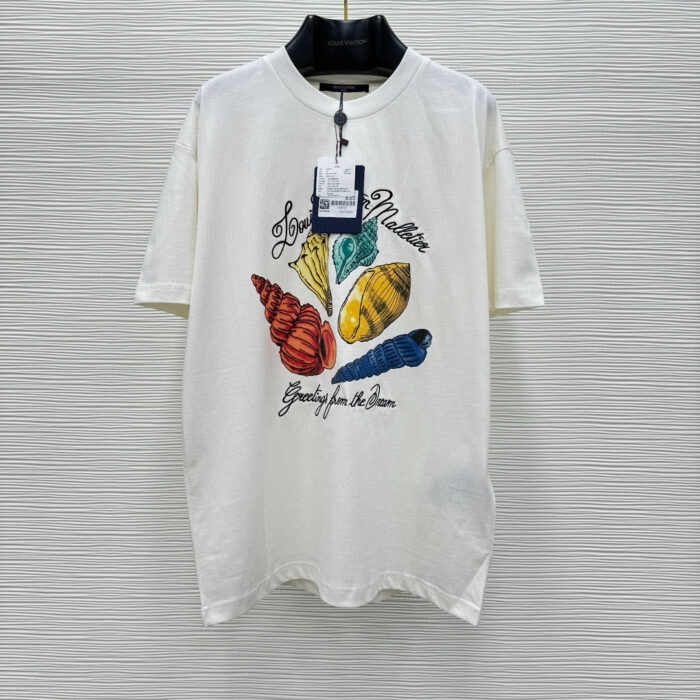 Maglietta estiva con conchiglie colorate e messaggio Greetings from the Sea per look casual e beach.