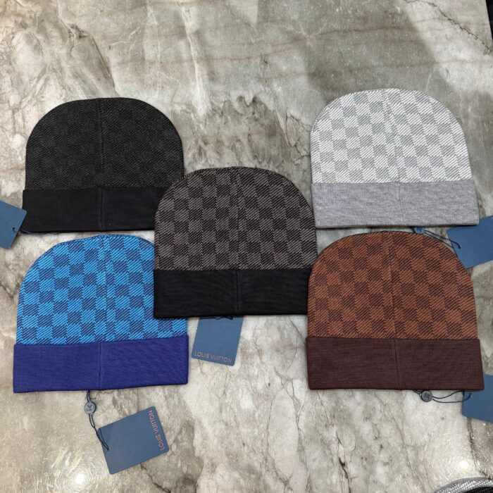 Beanie a quadretti in toni scuri, perfetti per il inverno, su superficie in marmo elegante.