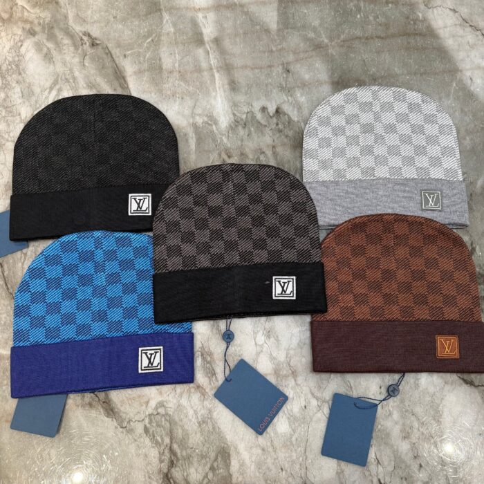 Set di cappelli beanie checkered in vari colori eleganti su superficie in marmo.