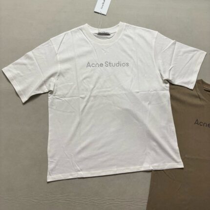 Maglietta off-white Acne Studios casual e moderna, con logo minimalista e tag visibile.