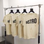 Magliette beige con scritta BISTRO in display moderno, stile vintage e look casual.