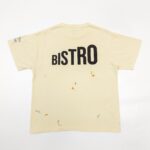 T-shirt beige con stampa BISTRO e dettagli artistici, stile casual e originale.