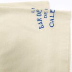 Tessuto beige con stampa blu Le Bar Dè, stile casual ed elegante.