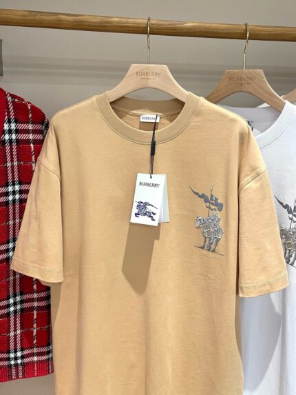 T-shirt beige con ricamo unicorno, stile casual moderno, su sfondo di abbigliamento trendy.