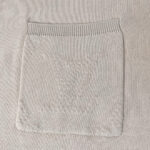 Maglione beige con tasca decorativa e collo a coste, tessuto caldo e dettagli eleganti.