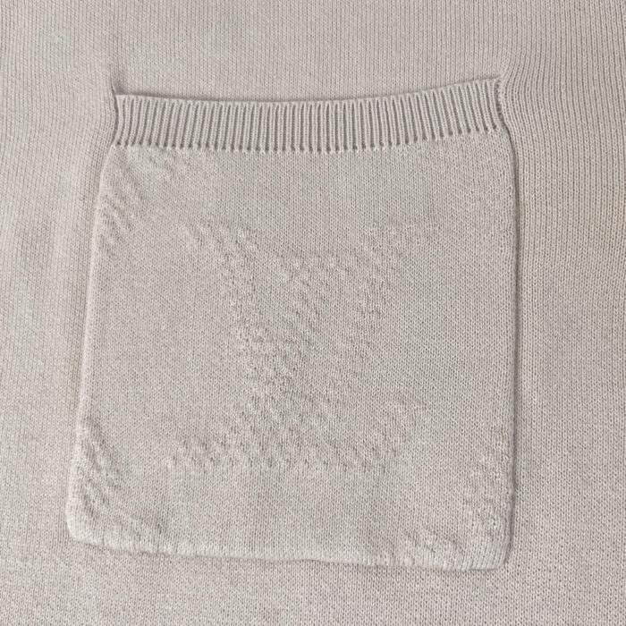 Maglione beige con tasca decorativa e collo a coste, tessuto caldo e dettagli eleganti.