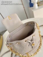 Borsa a secchiello beige con catena doro e design di lusso elegante e versatile.