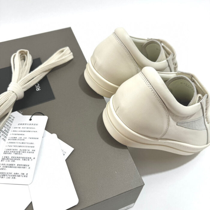 Sneakers beige minimaliste in packaging elegante, perfette per stile casual e sofisticato.