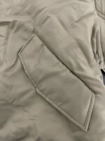 Cappotto beige con tasca a patta moderna e dettagli eleganti per uno stile contemporaneo.