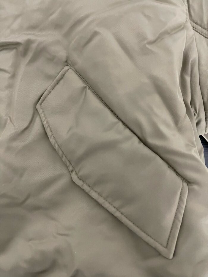 Cappotto beige con tasca a patta moderna e dettagli eleganti per uno stile contemporaneo.