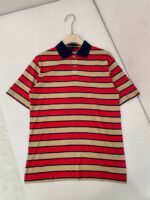 Polo uomo a righe rosso, beige e navy con colletto, taschino e bottoni, stile casual elegante.