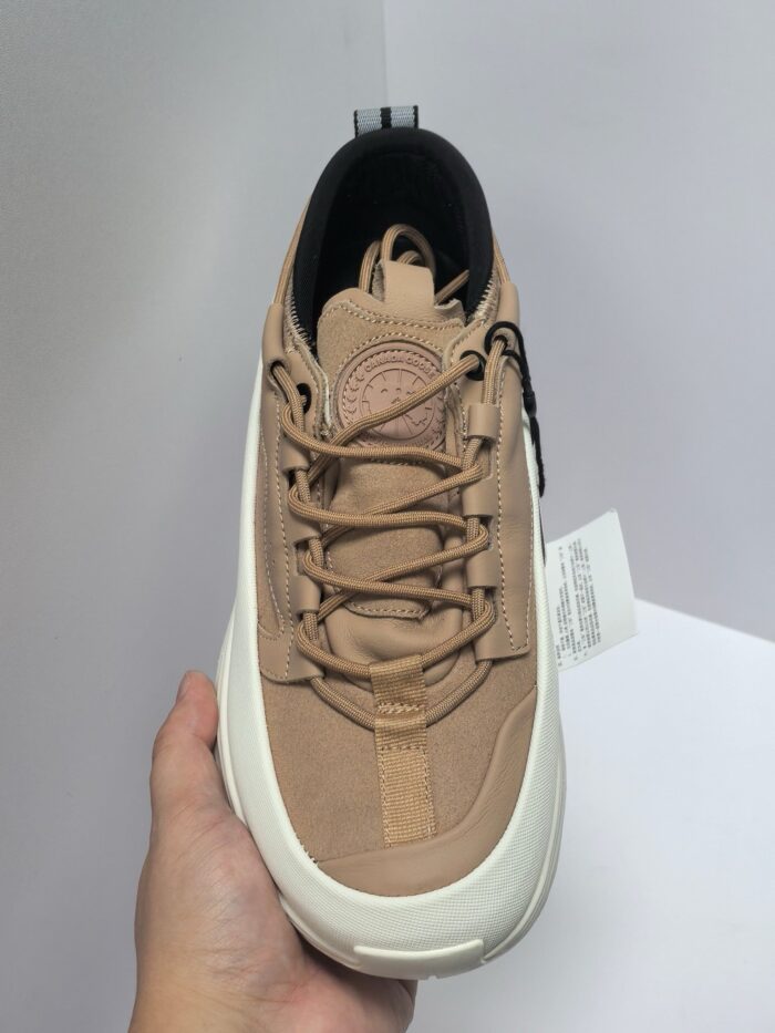 Sneaker beige in suede con suola bianca antiscivolo e logo sulla linguetta.