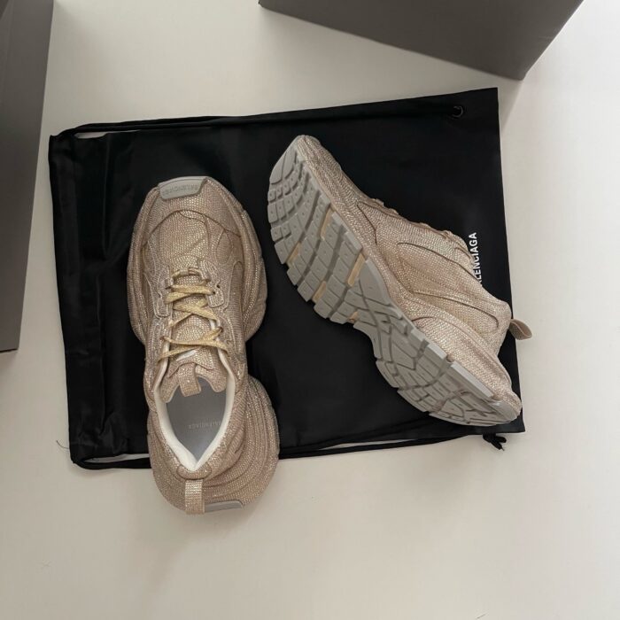 Scarpe beige moderne con suola robusta su borsa nera, stile casual e comfort versatile.