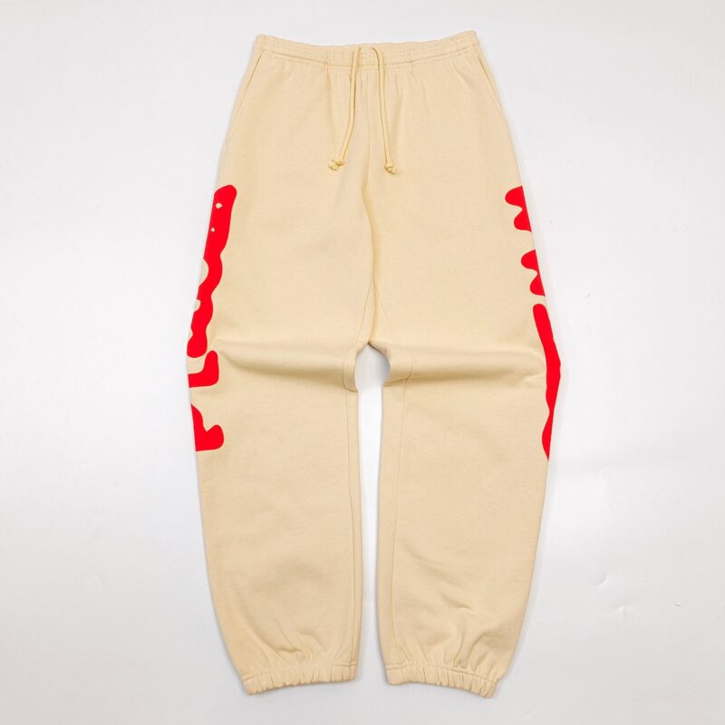 Pantaloni jogger beige con design artistico rosso, elastici e vestibilità comoda per streetwear casual.