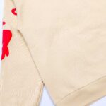 Felpa beige con grafica rossa urban style, morbida e comoda per look casual e trendy.