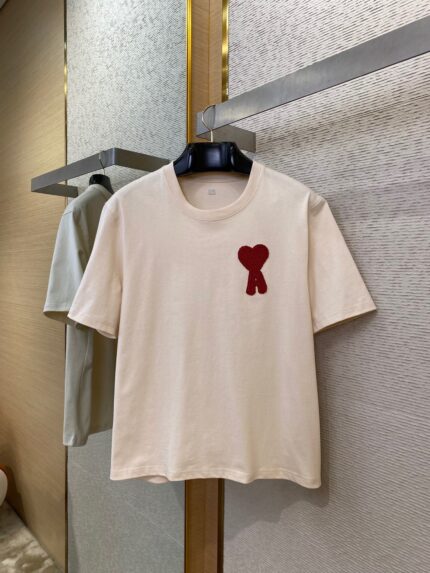 T-Shirt beige con cuore rosso applicato, stile casual e moderno, perfetto per ogni occasione.