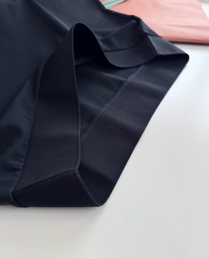 Tessuto nero elegante con dettagli rosa, perfetto per uno stile moderno e versatile.