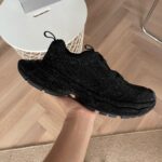Scarpa da corsa nera moderna, dettagli riflettenti, grip antiscivolo, stile e comfort superiore.