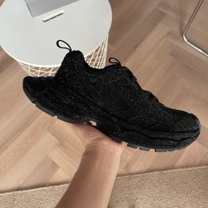 Scarpa da corsa nera moderna, dettagli riflettenti, grip antiscivolo, stile e comfort superiore.