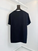 T-shirt nera basic su appendiabiti minimalista, stile elegante e discreto per il guardaroba quotidiano.