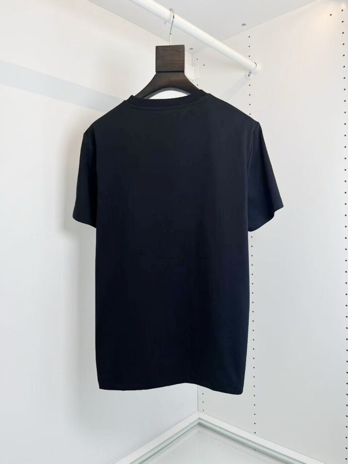 T-shirt nera basic su appendiabiti minimalista, stile elegante e discreto per il guardaroba quotidiano.