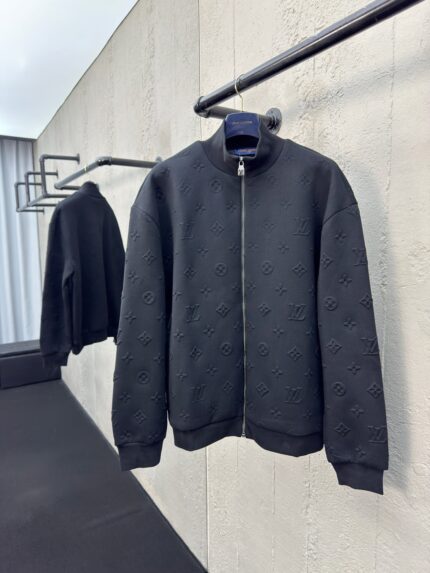 Giacca bomber nera in stile industriale, tessuto texturizzato, design oversize, modernità elegante.