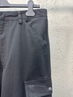 Pantaloni cargo neri moderni, tessuto resistente, tasca utility con bottone, stile urbano e versatile.