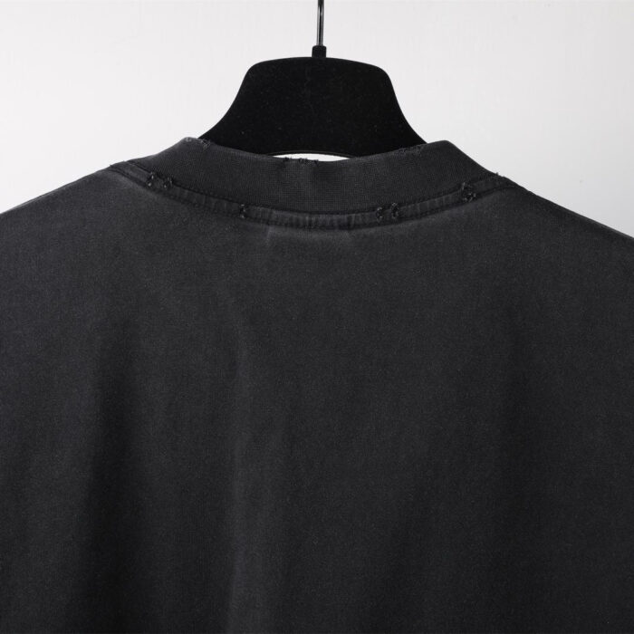 Maglione nero con girocollo in cotone morbido, minimalista e versatile su appeso.