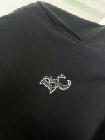 Maglietta nera semplice con logo ricamato B C, stile elegante e casual.