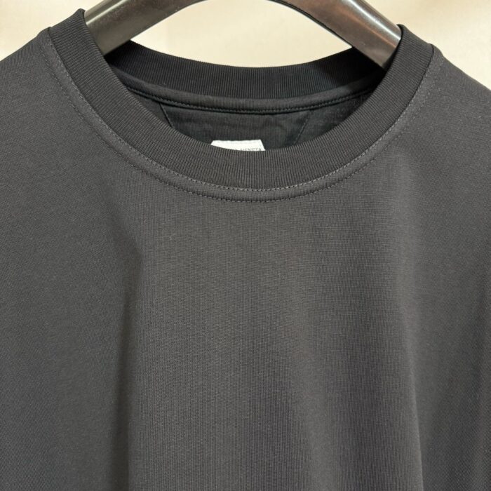 Maglietta nera a girocollo in tessuto di alta qualità, versatile e dal design semplice ed elegante.
