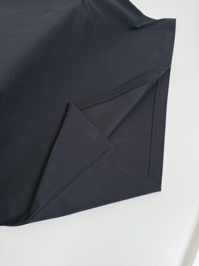 Dettaglio di tessuto nero di alta qualità, morbido e elegante per abbigliamento casual e versatile.