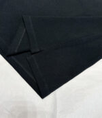 Tessuto nero con pieghe eleganti, finitura precisa, ideale per moda e arredamento.
