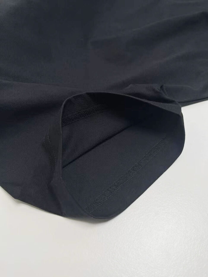 Dettaglio manica nera in tessuto sottile, elegante e di alta qualità.