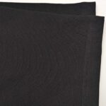 Tessuto nero morbido, lucente, con cuciture precise, ideale per moda e decorazioni eleganti.