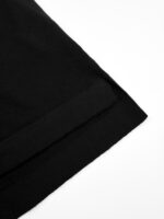 Dettaglio dellorlo in tessuto nero elegante e minimalista su sfondo bianco.