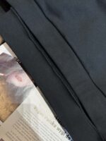 Vestito nero sopra rivista di moda e bellezza, dettagli di tessuto e immagine di labbra femminili.