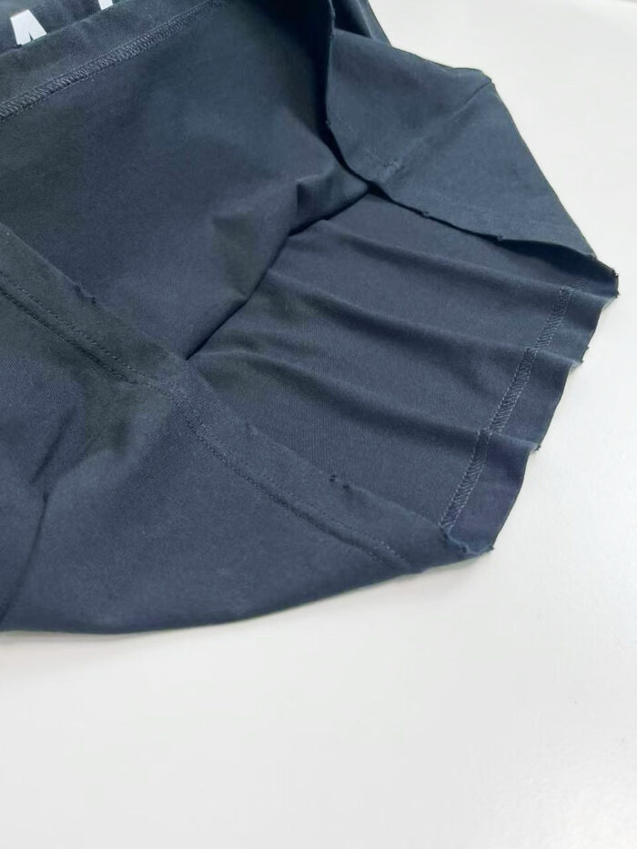 Tessuto nero con pieghe eleganti e dettagli di sartoria, ideale per capi sofisticati.