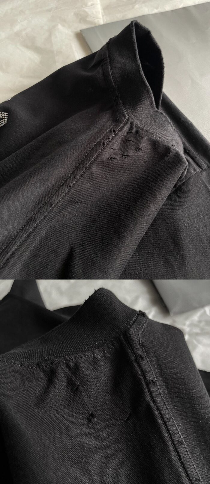Dettaglio di camicia nera in tessuto morbido con colletto stondato e cuciture precise.