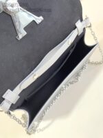 Borsa elegante in pelle nera con catena argento e logo raffinato, perfetta per ogni occasione.