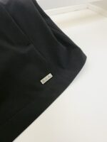 Maglietta nera elegante con etichetta metallica, design moderno e tessuto di alta qualità.