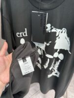 T-shirt nera con grafica dinamica, testo erd e dettagli di alta qualità.