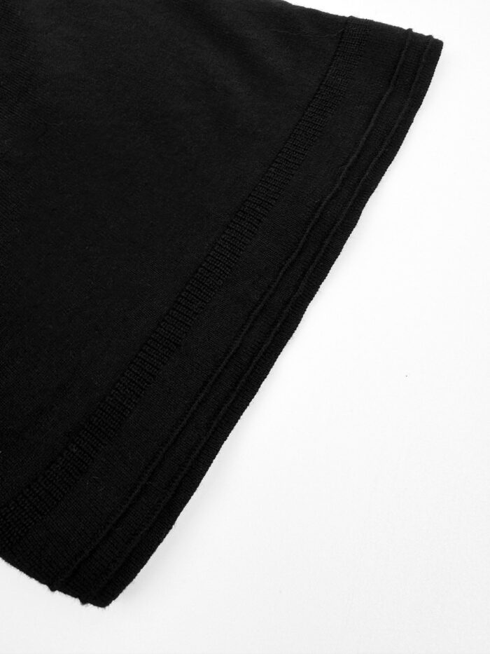 Orlo di maglietta nera in cotone, cuciture precise e finitura elegante.